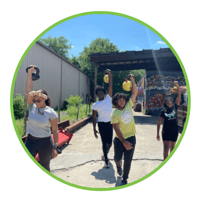 A group of girls doing kettlebell exercises outside
